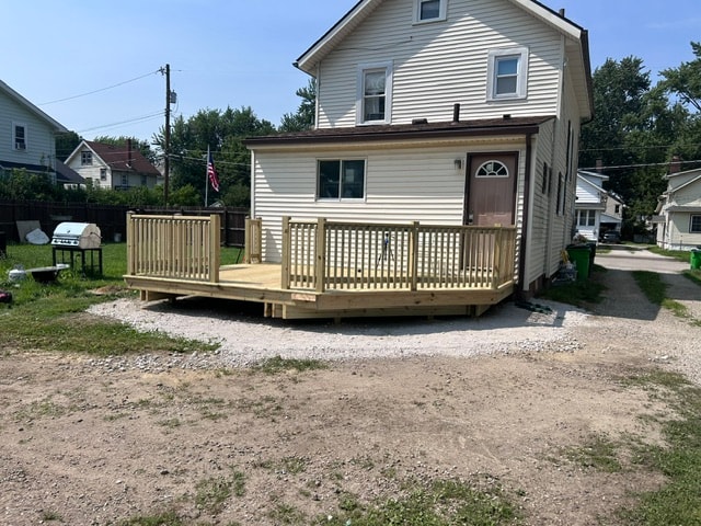 Finished residential deck with railing on back of house