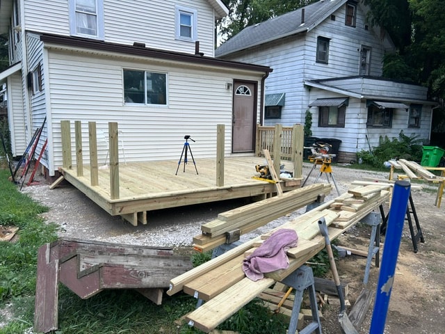 Deck mid-construction with decking boards going down and tools on site