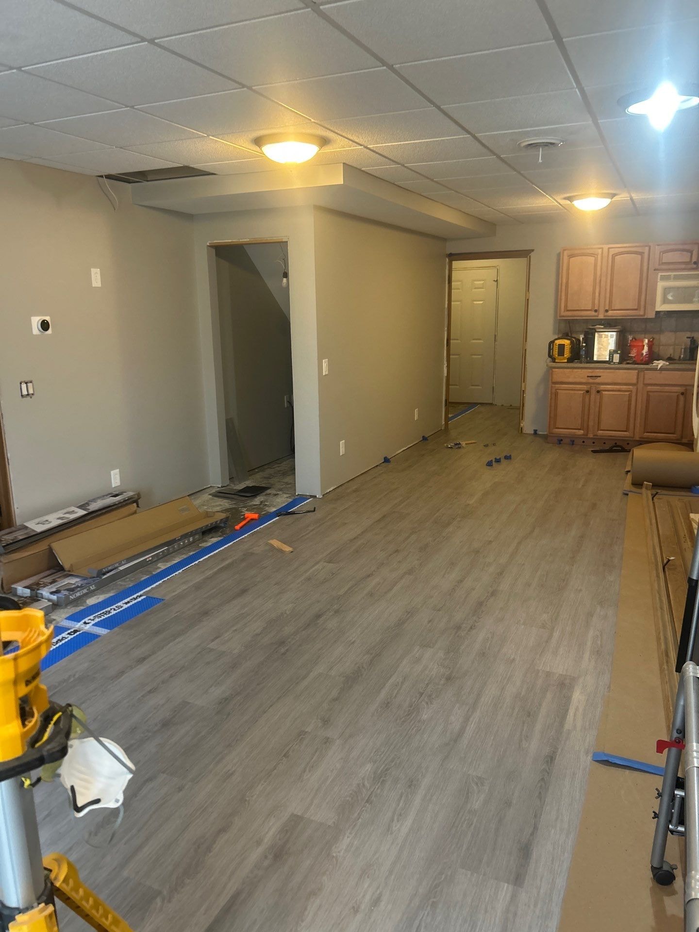 LVP flooring being installed across open basement space