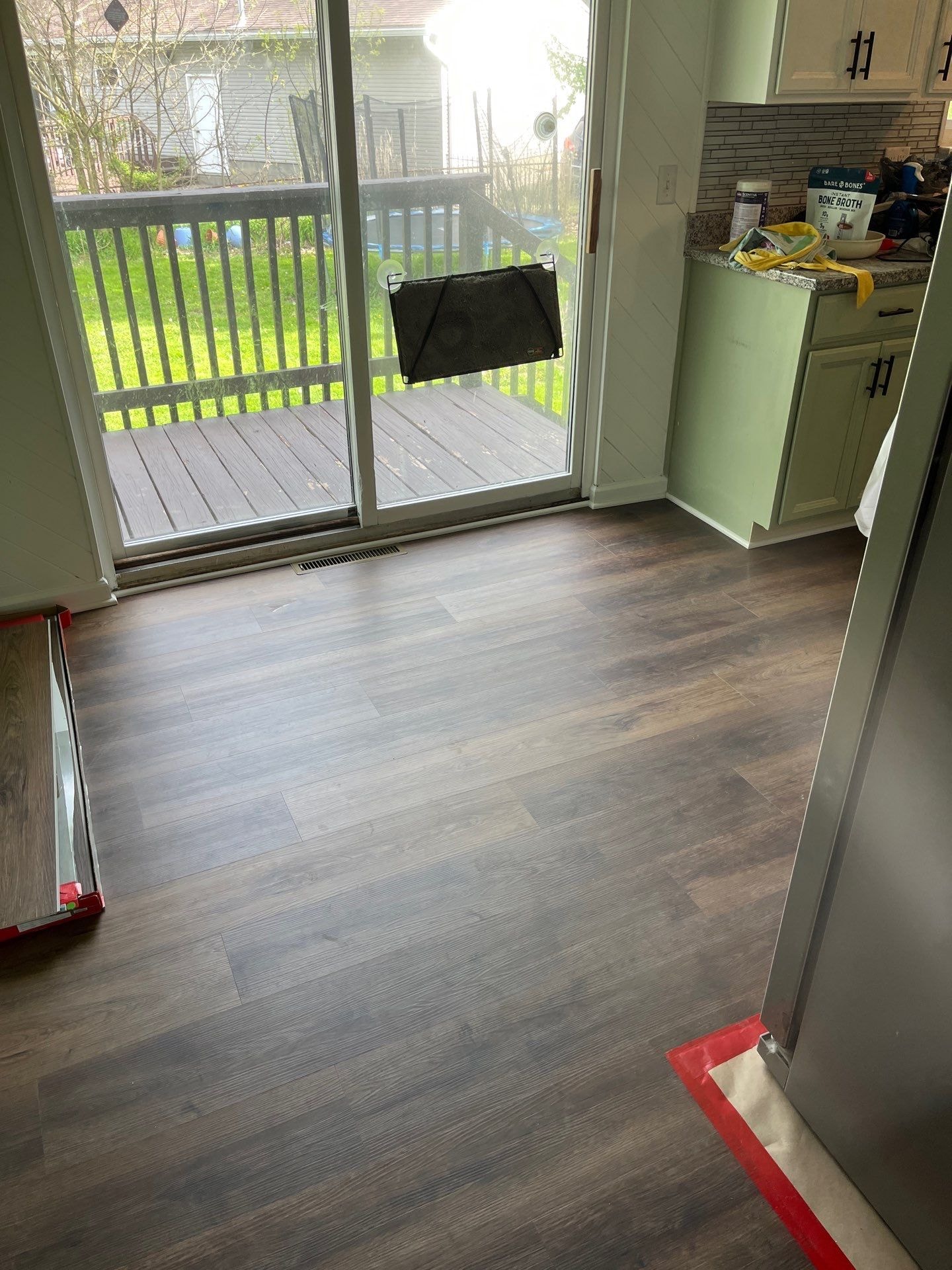 LVP flooring installed in kitchen and dining area with sliding glass door