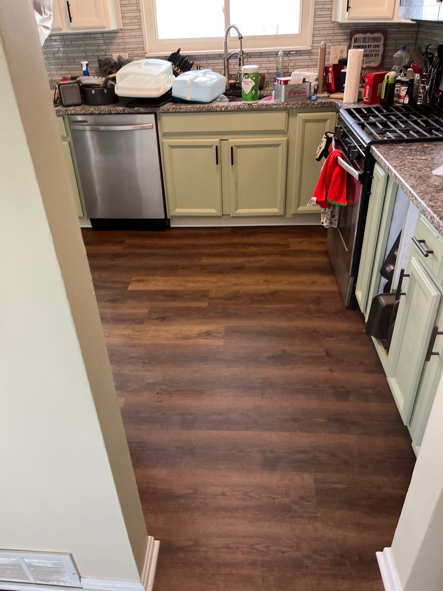 LVP flooring in kitchen with sage green cabinets