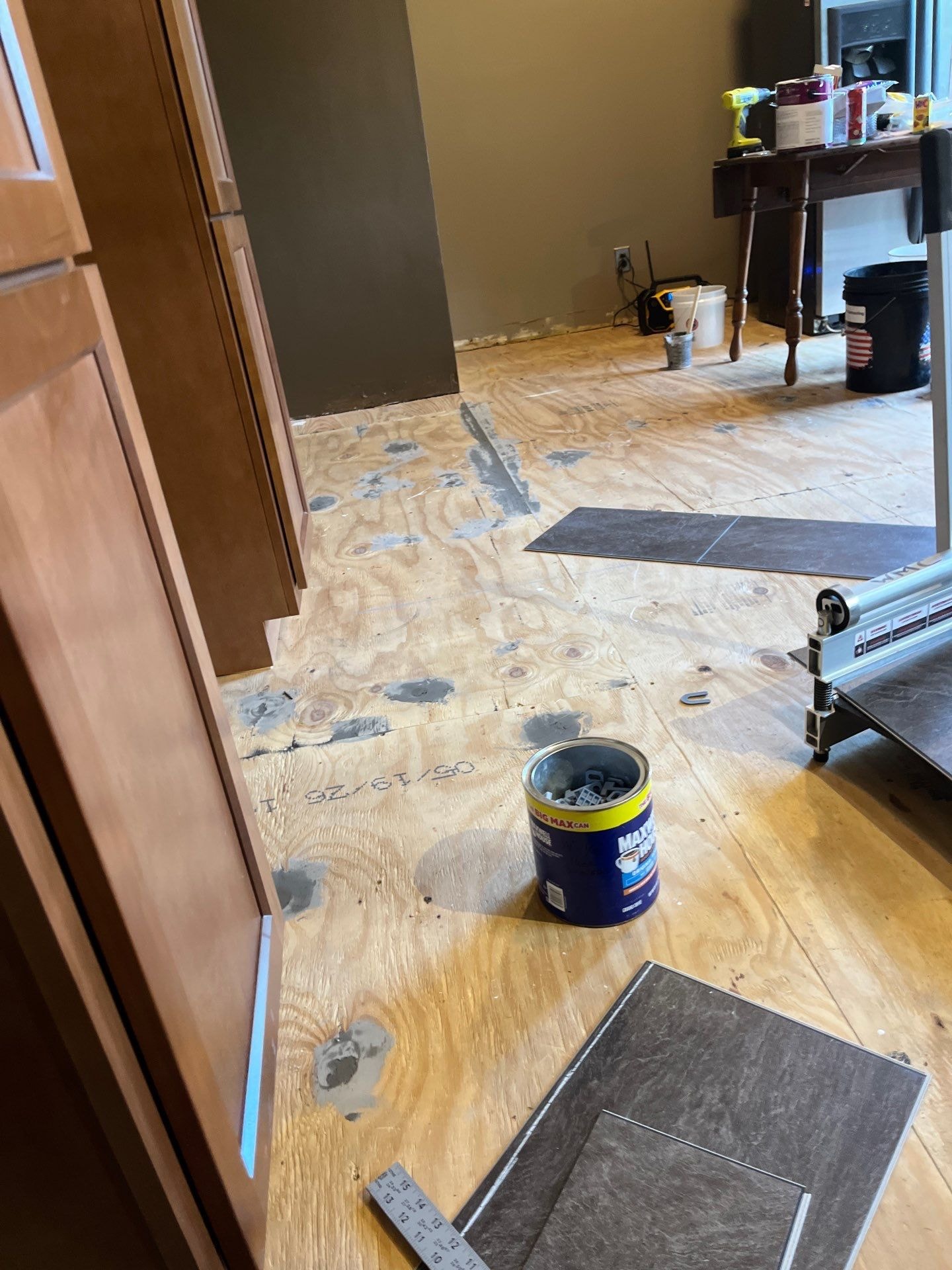 Tile-look LVP flooring installation in progress with subfloor prep and tile samples