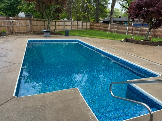 Completed vinyl liner pool installation full of water in residential backyard
